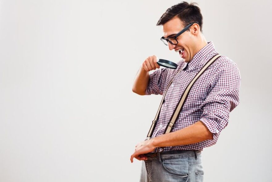 A man looks at a limb through a magnifying glass. 